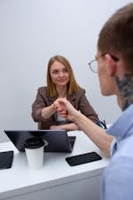 two-business-professionals-shaking-hands-across-a